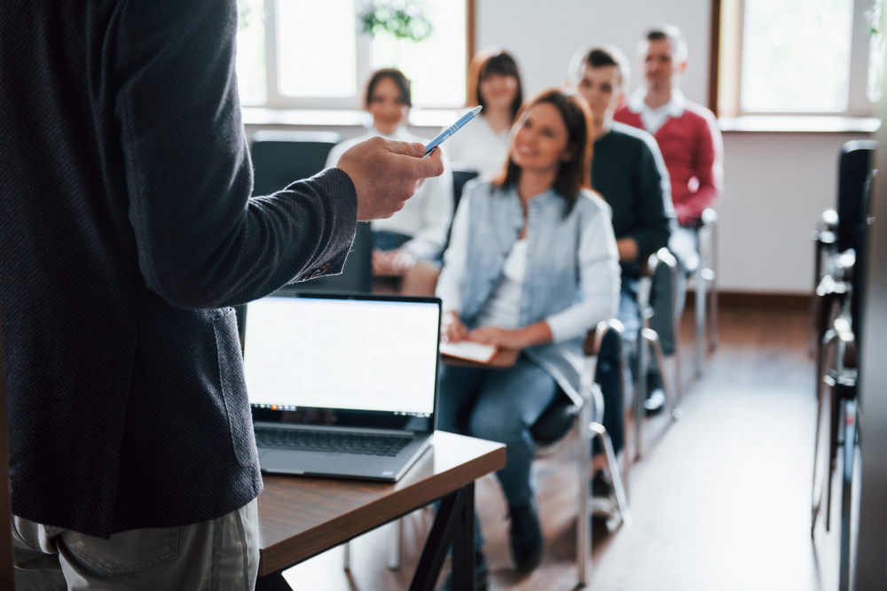 Man standing in front of classroom with laptop